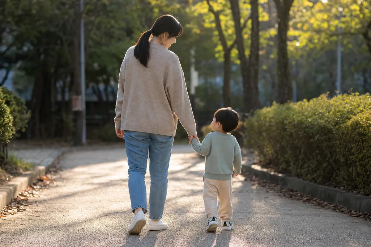 부모와 아이가 손을 잡고 공원 길을 걸어가는 뒷모습